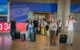 Des passagers arrivant à l'aéroport international Ben Gurion, près de Tel Aviv, tandis que des militants de différents partis politiques les attendent pour les inciter à voter pour leur formation lors des prochaines élections, le 25 octobre 2026. (Crédit : Rachel Alroey/Flash90)