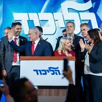 Le Premier ministre Benjamin Netanyahu salue ses partisans tôt dans la matinée au siège électoral du Likud à Jérusalem, du 28 octobre 2026. (Crédit : Chaim Goldberg/Flash90)