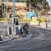 Des soldats israéliens montent la garde à un poste de contrôle situé à l’entrée de la ville, quelques jours après une fusillade survenue dans la région, à Hébron, en Cisjordanie, le 28 octobre 2026. (Crédit : Wisam Hashlamoun/Flash90)