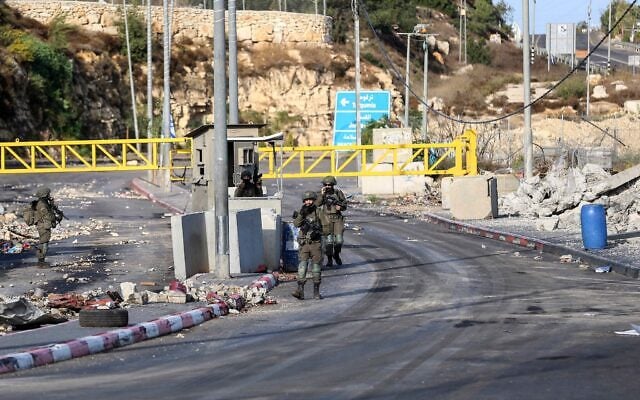 Des soldats israéliens montent la garde à un poste de contrôle situé à l’entrée de la ville, quelques jours après une fusillade survenue dans la région, à Hébron, en Cisjordanie, le 28 octobre 2026. (Crédit : Wisam Hashlamoun/Flash90)