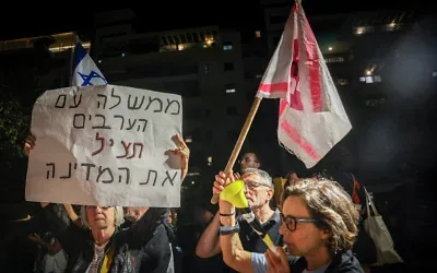 Des militants israéliens manifestent devant le domicile du président du parti Yashar, Gadi Eisenkot, à Herzliya, l’appelant à former un gouvernement alternatif avec le soutien des partis arabes, deux jours après les élections, le 29 octobre 2026. Sur la pancarte : "Un gouvernement avec les Arabes sauvera le pays". (Crédit: Miriam Alster/Flash90)