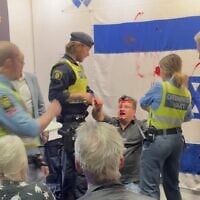 L'homme qui a jeté de la peinture rouge sur un drapeau israélien exposé au stand de l'Association d'amitié Suède-Israël le 3 octobre 2026 au Salon du livre de Göteborg, en Suède. (Capture d'écran - Instagram @riksstudios)