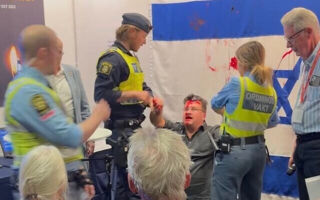 L'homme qui a jeté de la peinture rouge sur un drapeau israélien exposé au stand de l'Association d'amitié Suède-Israël le 3 octobre 2026 au Salon du livre de Göteborg, en Suède. (Capture d'écran - Instagram @riksstudios)