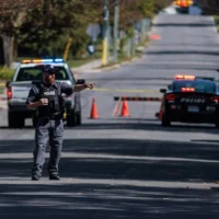 Un technicien de police scientifique désigne un véhicule de police sur les lieux de la fusillade à la synagogue Sons of Jacob. (Crédit : Nick Lachance/Toronto Star/JTA)