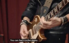 Un guitariste joue dans une scène du documentaire The Bridge. (Crédit : capture d’écran/The Bridge)