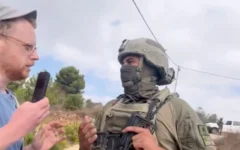 Un soldat masqué affronte un militant de l’association "Rabbis for Human Rights" pendant la saison de la récolte des olives près de Birzeit, à proximité de Ramallah, au centre de la Cisjordanie, le 9 octobre 2026. (Capture d’écran : X/Rabbis for Human Rights)