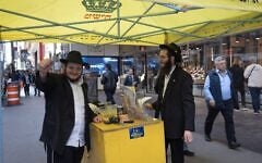 Shmuel Cohen (à gauche) faisant une pause après avoir aidé des passants à mettre leurs tefillin dans le Diamond District de New York, le 23 octobre 2026. (Crédit : Joseph Strauss/JTA)