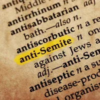 Le mot « antisémite » dans un ancien dictionnaire à la couverture texturée. Illustration. (Crédit : goglik83/iStock via Getty Images)
