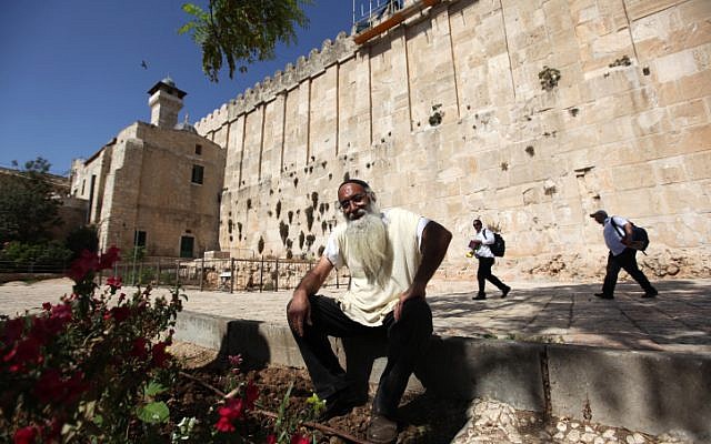 A Jewish settler sits outside the Tomb of the Patriarchs in the West Bank city of Hebron (Kobi Gideon/Flash90) Jewish settler sits outside the Tomb of the Patriarchs in the West Bank city of Hebron (photo credit: Kobi Gideon/Flash90)
