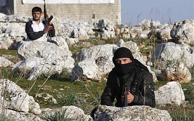 Syrian rebels are seen outside of Idlib, Syria, on Saturday (photo credit: AP)