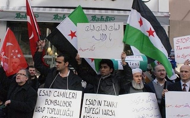 Syrians living in Turkey protest the latest killings by the Syrian regime. (photo credit: AP) Syrians living in Turkey protest the latest killings by the Syrian regime. (photo credit: AP)