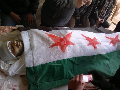 A Syrian protester, killed by the army, is prepared for burial on Sunday (photo credit: Local Coordination Committees in Syria/AP)