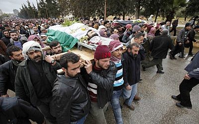 A boy's body being carried through the Syrian city of Idlib Thursday. (photo credit: AP)