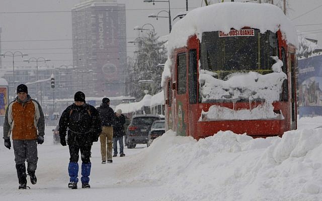 Bosnians walk near a frozen tram in the Bosnian capital of Sarajevo, on Saturday, Feb. 4, 2012. (photo credit: AP/Amel Emric)