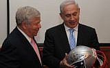 Robert K. Kraft (left) hands Israeli Prime Minister Benjamin Netanyahu a helmet signed by the New England Patriots football players in February 2012. (Photo credit: Amos BenGershom / GPO/Flash90)