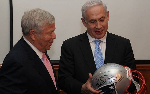 Robert K. Kraft (left) hands Israeli Prime Minister Benjamin Netanyahu a helmet signed by the New England Patriots football players in February 2012. (Photo credit: Amos BenGershom / GPO/Flash90)
