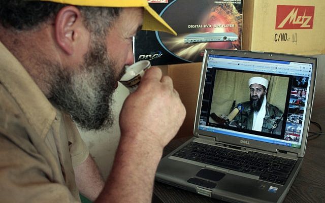 A man in Hebron watches the news on his computer. (photo credit: Najeh Hashlamoun /Flash 90)