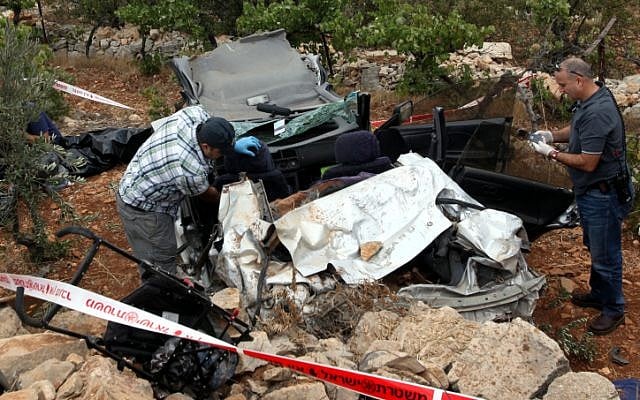 Rescue personnel at the scene where Asher Hillel Palmer and his son were killed  after rocks were thrown at their vehicle on Route 60 near Kiryat Arba last September. (photo credit: Yossi Zamir/Flash 90)