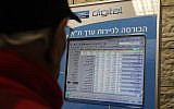 A man looks at screen listing prices of the Tel Aviv Stock Exchange (illustrative photo credit: Yossi Zamir/Flash 90)