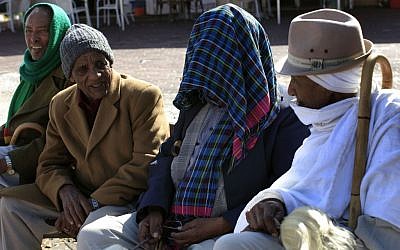 Ethiopian Jews sitting in the sun in Ashkelon in late January. (Photo credit: Tsafrir Abayov/Flash90)