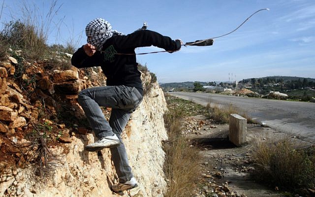 A Palestinian demonstrator runs for cover as Israeli soldiers fire tear gas during a protest  in the West Bank village of Nabi Saleh near Ramallah. (photo credit: Issam Rimawi/FLASH90)