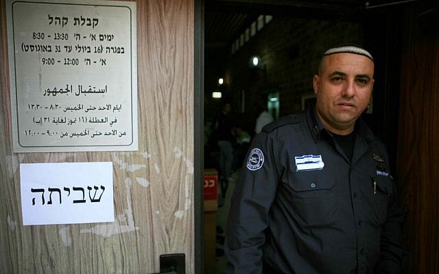 A security guard stands outside a closed office in kfar Sava Thursday. (photo credit: Yehoshua Yosef/Flash90)