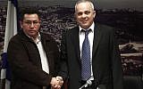 A stern looking Histadrut Chairman Ofer Eini shakes hands with smiling Finance Minister Yuval Steinitz during a joint press conference Sunday morning after all-night negotiations that ended the general strike (photo credit: Uri Lenz/Flash90)