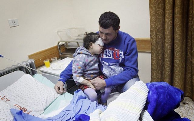 A man comforts his injured daughter at a Ramallah hospital. (photo credit: Miriam Alster/Flash 90)