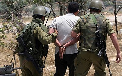 The IDF arrest a protester in this file photo. (photo credit: Ahmad Gharabli/Flash90)