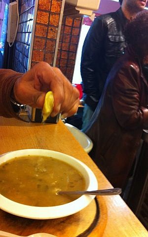 A customer adds a bit of lemon to his soup at Marakei and Felafel Gabai (photo credit: Michal Shmulovich, Times of Israel) A customer adds a bit of lemon to his soup at Marakei and Felafel Gabai (photo credit: Michal Shmulovich, Times of Israel)
