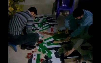 Volunteers paint opposition flags in Idlib, Syria (photo credit: Ugarit News)