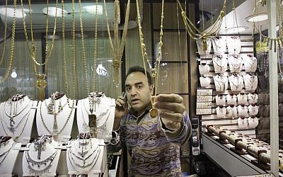 An Iranian goldsmith adjusts a gold necklace at the gold market of Tehran's old main bazaar. (photo credit: c/o AP)
