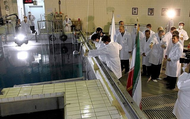 Iranian President Mahmoud Ahmadinejad, right, is escorted by technicians during a tour of Tehran's research reactor center in February 2012 (photo credit: AP/Iranian President's Office)