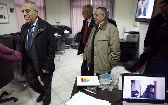 Palestinian Prime Minister Salam Fayyad (left) visits the offices of al-Watan TV after a pre-dawn IDF raid in Ramallah on Wednesday. The computer screen on the right shows a soldier during the raid. (photo credit: AP/Majdi Mohammed) Palestinian Prime Minister Salam Fayyad (left) visits the offices of al-Watan TV after a pre-dawn IDF raid in Ramallah on Wednesday. The computer screen on the right shows a soldier during the raid. (photo credit: AP/Majdi Mohammed)