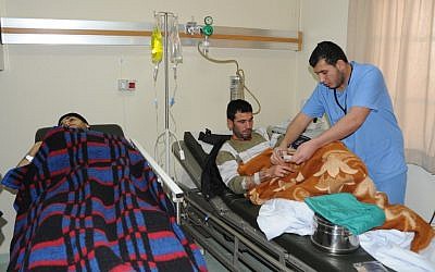 Syrian men who were wounded from the shelling at Baba Amr neighborhood in the Syrian province of Homs (photo credit: AP/Samer Husseini)