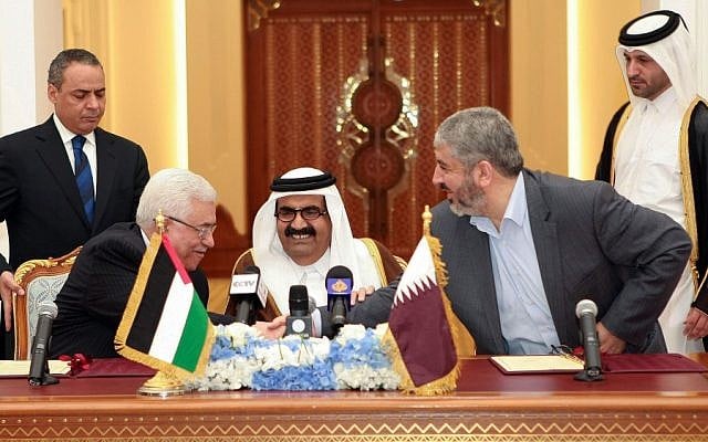 Palestinian President Mahmoud Abbas, left, shakes hands with Hamas leader Khaled Mashaal, right, as the Emir of Qatar, Sheikh Hamad bin Khalifa Al Thani, center, looks on Monday. (photo credit: AP/Osama Faisal)