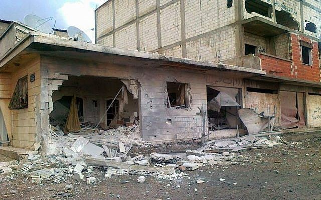 In this citizen journalism image houses are seen destroyed from Syrian army shelling on Homs (photo credit: AP Photo/Local Coordination Committees in Syria)