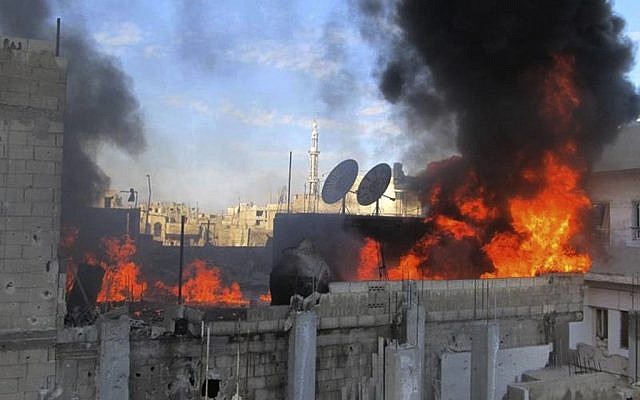 A house burns after Syrian government shelling in the Baba Amr neighborhood in Homs province, in this citizen journalism image. (file photo; photo credit: AP/Local Coordination Committees in Syria) A house burns after Syrian government shelling in the Baba Amr neighborhood in Homs province, in this citizen journalism image. (file photo; photo credit: AP/Local Coordination Committees in Syria)
