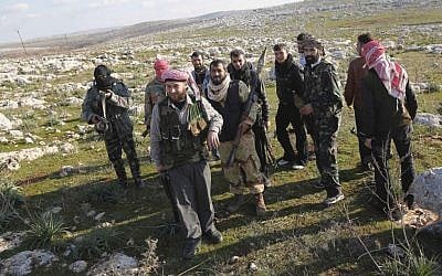 Syrian rebels are seen outside of Idlib, Syria, Saturday. The foreign ministers of the Arab League are meeting in Cairo Sunday to decide on re-sending an observer mission to Syria amid the dramatic surge in violence. (photo credit: AP)