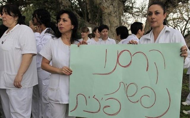 Nurses from Barzilai hospital hold a sign reading "we've collapsed mentally and physically" (photo credit: Tsafrir Abayov/Flash90)