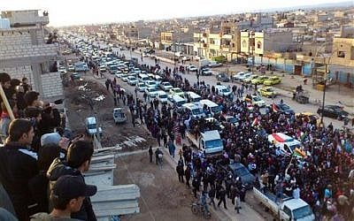 In this Wednesday, Feb. 22, image provided by the Local Coordination Committees in Syria, anti-Syrian regime protesters hold up Kurdish flags during a rally in the northeastern town of Qamishli, Syria. (AP /Local Coordination Committees in Syria)