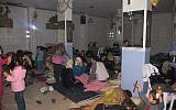 In this undated citizen journalism image accessed on Thursday, Syrian families gather at a shelter hiding from Syrian government forces shelling, in the Baba Amr neighborhood of Homs province. (photo credit: AP Photo/Local Coordination Committees in Syria)