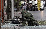 A Thai Explosive Ordnance Disposal official examines a backpack left at the bomb site in Bangkok last week (photo credit: AP/Apichart Weerawong)