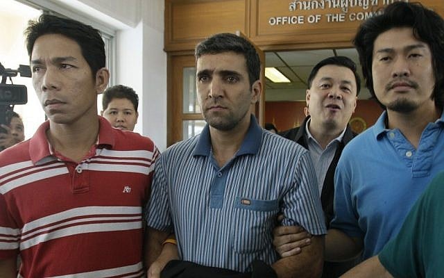 Thai immigration officers escort detained Iranian Mohammad Kharzei (center) at immigration headquarters in Bangkok. (photo credit: AP) Thai immigration officers escort detained Iranian Mohammad Kharzei (center) at immigration headquarters in Bangkok. (photo credit: AP)
