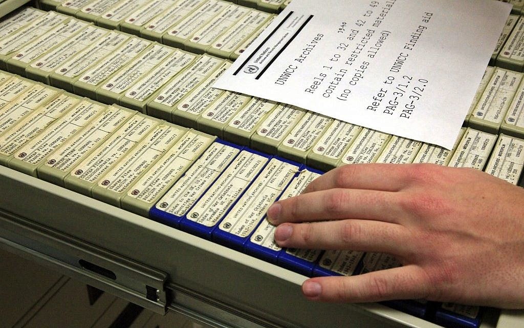 A researcher in New York opens a drawer containing some of the 184 reels of microfilmed documents with data on World War II criminals. (photo credit: AP/Bebeto Matthews)
