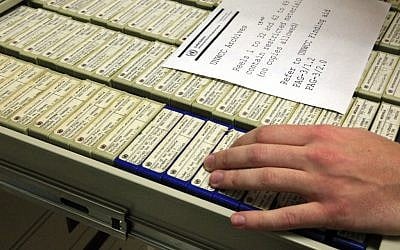 A researcher in New York opens a drawer containing some of the 184 reels of microfilmed documents with data on World War II criminals. (photo credit: AP/Bebeto Matthews)