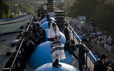 Ultra-Orthodox people pray at the tomb of Rabbi Shimon Bar Yochai on Mount Meron (photo credit: Ariel Schalit/AP)