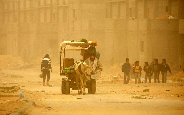 Palestinians walk in the street a during cold winds and sand storms in the southern Gaza Strip town of Rafah on February 7, 2012. (photo credit: Abed Rahim Khatib/Flash 90)