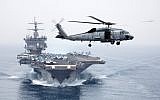 A Sea Hawk helicopter flies in front of the 5th Fleet's USS Enterprise. (photo credit: CC BY Official U.S. Navy Imagery, Flickr)