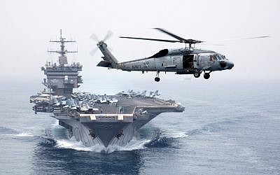 A Sea Hawk helicopter flies in front of the 5th Fleet's USS Enterprise. (photo credit: CC BY Official U.S. Navy Imagery, Flickr)